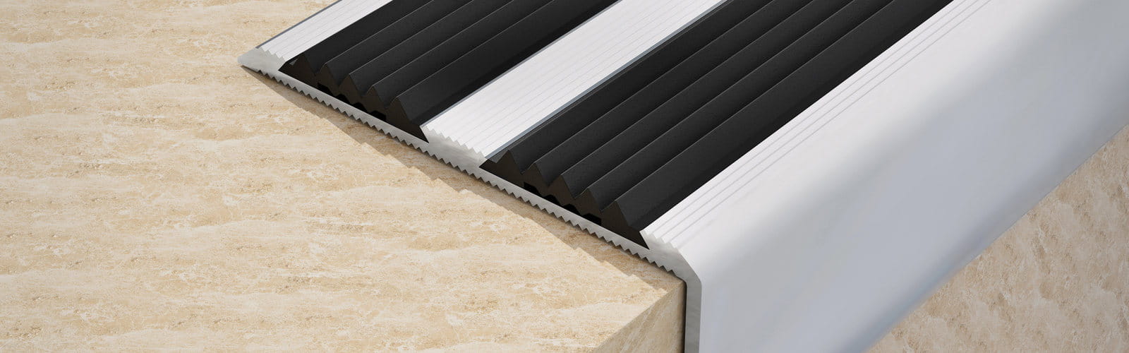 Aluminium stair nosing fitted to a stone step, showing the anti-slip inserts and front lip